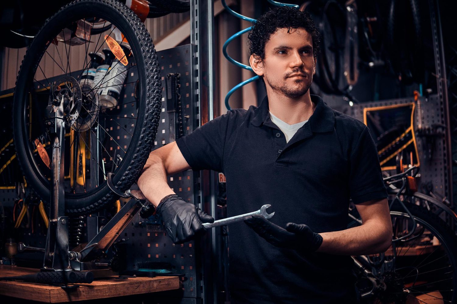 young-attractive-mechanic-is-posing-bicycle-his-own-workshop young attractive mechanic is posing bicycle his own workshop